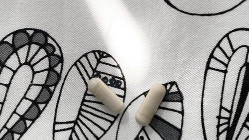 2 supplement capsules on a doodle background