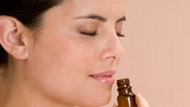 Woman smelling from essential oil bottle for smell training