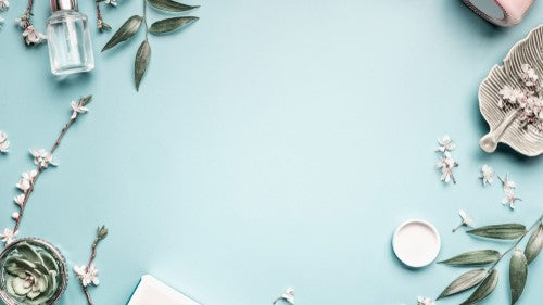 Beauty products and leaves on pale blue background