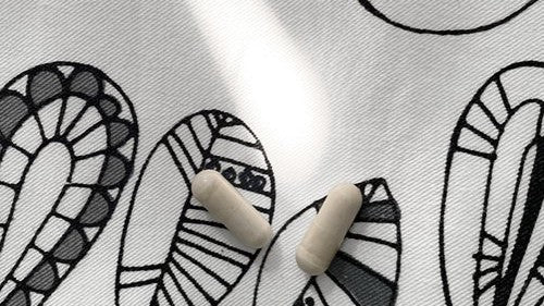 2 supplement capsules on a doodle background 