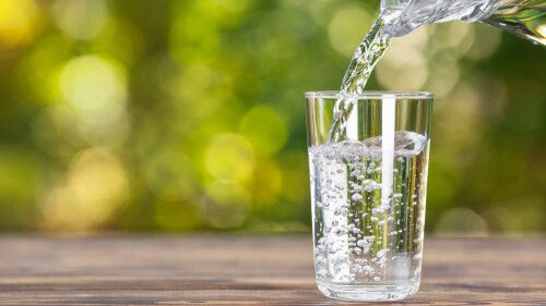 Sparkling glass of water being poured from a jug