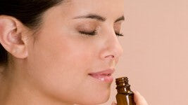 Woman smelling from essential oil bottle for smell training 