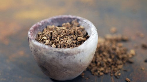 Grey stone bowl filled with ground valerian root